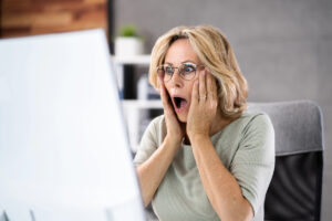 Woman shocked at computer screen