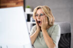 Frustrated businesswoman looking at her computer screen In dismay